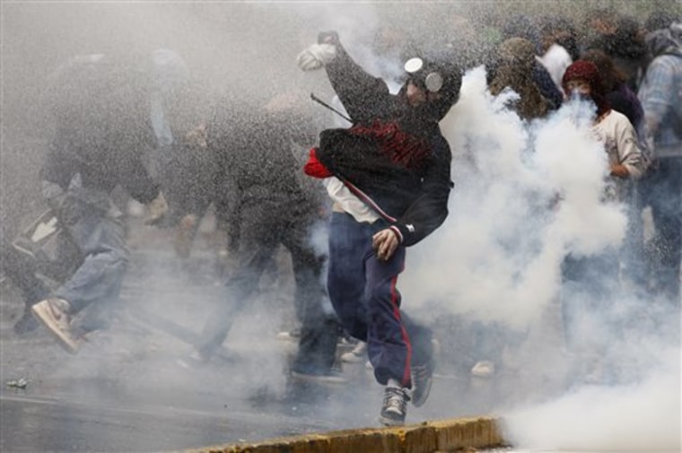 A demonstrator throws a stone at riot police Thursday during a demonstration in Santiago, Chile.